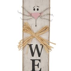 a wooden sign with a cat face and the word w e painted on it's side