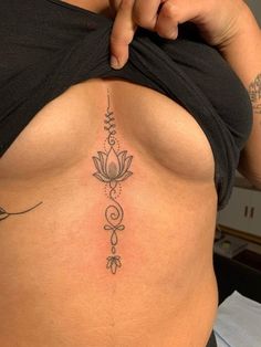 a woman's stomach with a tattoo on the side and an arrow in the middle