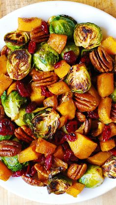 a white plate topped with brussel sprouts and sweet potatoes