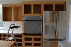 a kitchen with wooden cabinets and stainless steel appliances in the process of remodeling