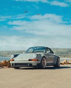 a grey porsche parked on the side of the road