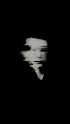 a blurry image of a person in the dark with their head turned to the side