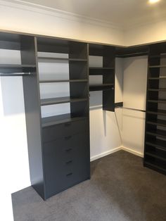 an empty walk in closet with black and white shelving units on the wall,