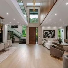 a living room filled with lots of furniture and a staircase leading up to the second floor