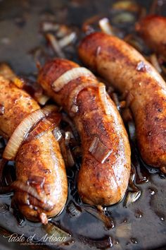 several sausages are being cooked in a frying pan