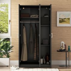 an open closet with clothes hanging on the door and other items in front of it