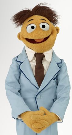 the muppet is dressed in a suit and tie with his hands on his hips