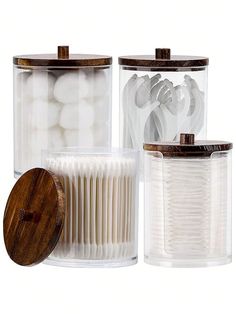 three clear containers with wooden lids are shown