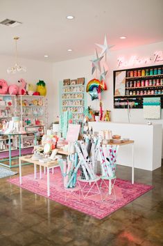 a room filled with lots of furniture and decor on top of a pink rug in front of a wall