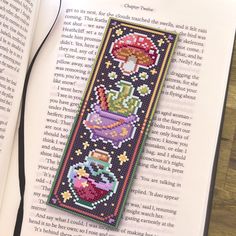 a cross stitch bookmark on top of an open book