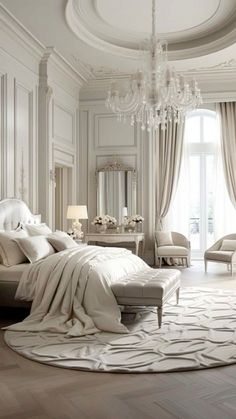 a white bedroom with chandelier, bed, and chair in it's center