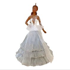 a doll is wearing a white dress with long sleeves and a high low neckline