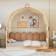 a child's bedroom with an arch bed and artwork on the wall behind it