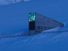 a building that is in the snow with lights on it's face and windows