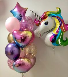 a unicorn balloon bouquet with balloons attached to the wall and hanging from it's side