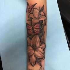 a woman's arm with flowers and butterflies tattoo on her left arm, while the rest of the arm is in full bloom