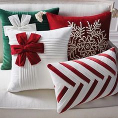 four pillows with bows and ribbons on them