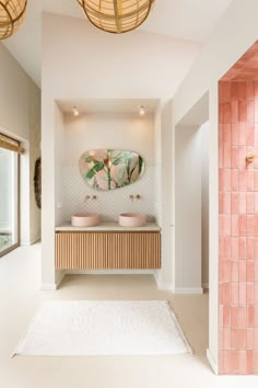 a bathroom with two sinks and a mirror on the wall next to an area rug