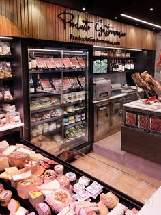 a deli filled with lots of different types of meat and cheeses on display