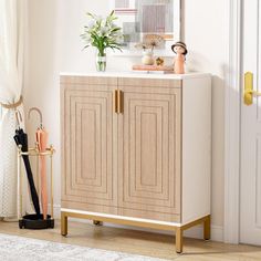 a white and gold cabinet in a room with a rug on the floor next to it