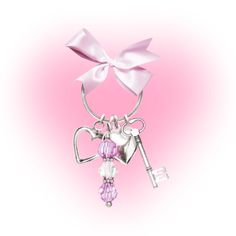 a key with a bow on it is attached to a keychain that has a heart and keys hanging from it