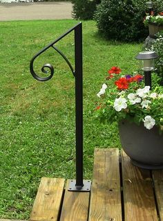 a potted plant sitting on top of a wooden table next to a lamp post