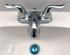 the faucet on the sink is shiny blue