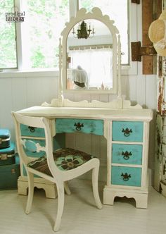 a white desk with blue drawers and a mirror