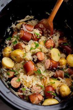 a crock pot filled with potatoes and ham