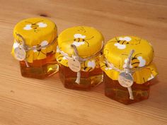 three honey jars with bees on them sitting on a table