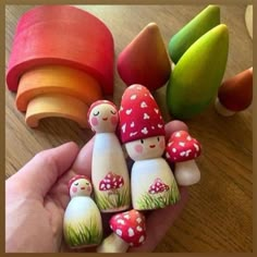 a hand holding a group of small wooden mushrooms