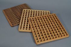 three wooden coasters sitting on top of a gray table next to eachother