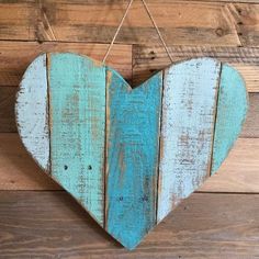 a heart shaped wooden sign hanging on a wall next to wood planks and string