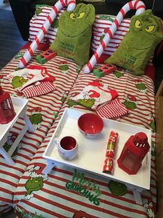 there is a bed with red and white striped sheets on it that has grinen decorations