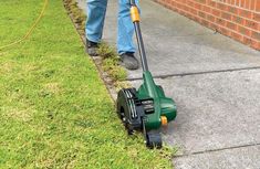 a man is using a lawn mower to cut the grass