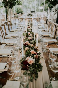 a long table is set with flowers and candles for an elegant dinner or wedding reception