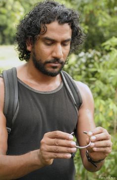 a man with curly hair is looking at his cell phone