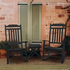 two rocking chairs sitting next to each other in front of an open window with shutters