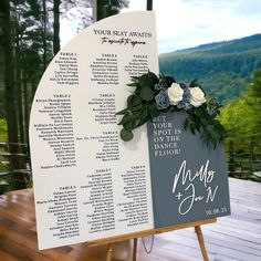 a seating sign with flowers and greenery on it