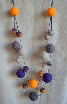 a necklace made out of felt balls and chains