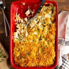 a red casserole dish filled with chicken and rice