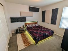 a bed sitting in a bedroom next to a window with blinds on the windowsill