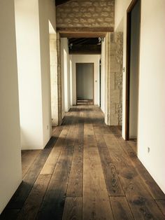 an empty hallway with wooden floors and white walls