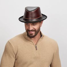 A smiling man wearing a wine colored fedora Elegant Leather Fedora For Fall, Western Style Leather Fedora For Formal Occasions, Classic Leather Hat Bands For Fall, Fitted Leather Hat Band For Fall, Formal Leather Hat With Short Brim, Fitted Leather Fedora For Fall, Leather Hat With Flat Brim For Formal Occasions, Adjustable Leather Hats For Formal Occasions, Formal Leather Hat With Curved Brim