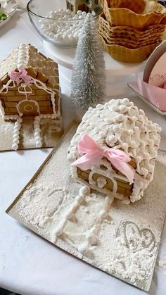 there are some cookies on the table with other items in the bowl behind them and one cookie is shaped like a house