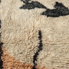 an area rug with black and white designs on the top, brown and beige colors