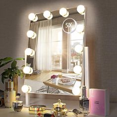 a vanity mirror with lights on it in front of a window and a potted plant