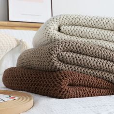 a stack of blankets sitting on top of a bed