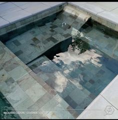 an empty pool with water reflecting the sky and clouds on it's surface,