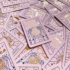 a pile of pink and gold stickers sitting next to each other on top of a table